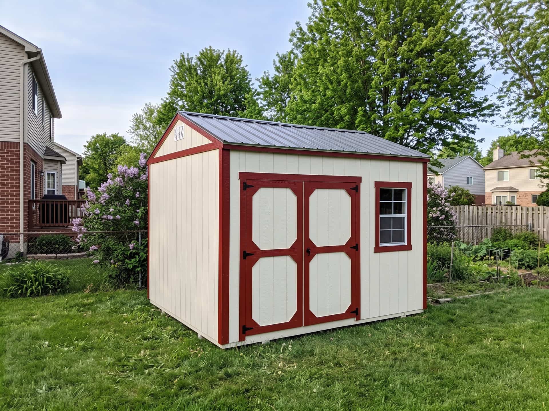 Amish-built garden shed with red trim on a Michigan property